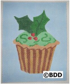 A cupcake with green frosting and holly leaves.