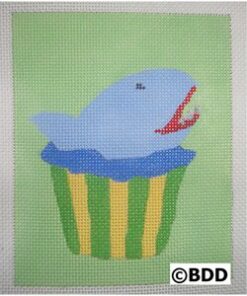 A blue whale sitting in a cup on top of a green and yellow striped background.