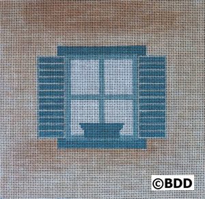 A blue window with shutters and a bowl on the sill.