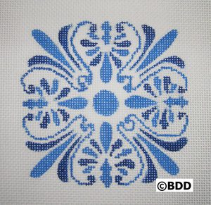 A blue and white pattern on the front of a cross stitch.