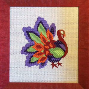 A colorful bird is depicted in this needlepoint picture.