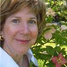 A woman standing in front of some bushes