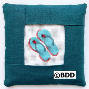 A blue pillow with a pair of flip flops on it.