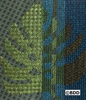 A close up of the fabric with green and blue designs.