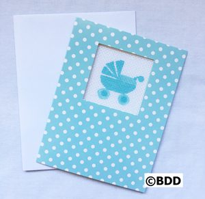 A baby carriage card sitting next to an open envelope.