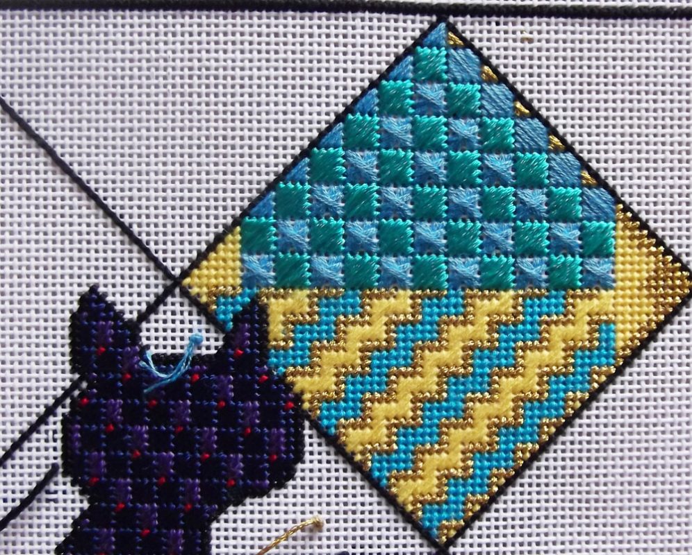 A cross stitch pattern of a cat and a diamond.