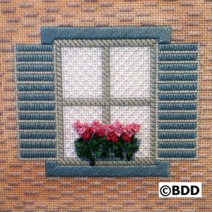 A window with shutters and flowers in the window.