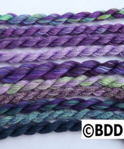 A group of purple and green yarn on top of each other.