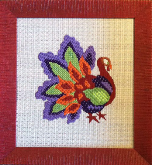 A cross stitch picture of a colorful bird.