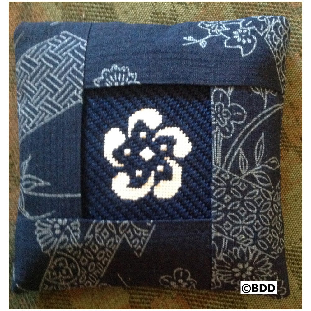 A blue pillow with a pattern of flowers.