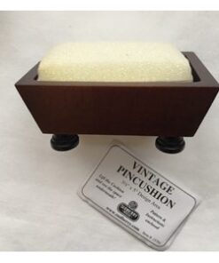 A soap dish with wooden legs and a card.