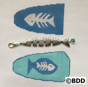 A fish bone and a fish hook with beads.