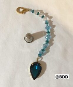 A blue and white beaded bracelet with a large pendant.
