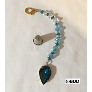 A blue and white beaded bracelet with a large pendant.