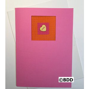 A pink card with an orange heart on it.