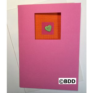 A pink card with an orange heart on it.