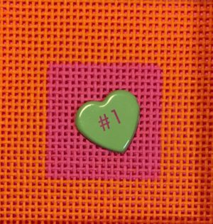 A green heart on top of a pink and orange background.