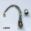 A bell is attached to the end of a beaded bracelet.