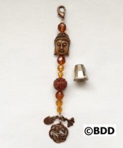 A metal bell with an ornament and beads.