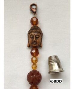 A thimble and bead with a buddha head