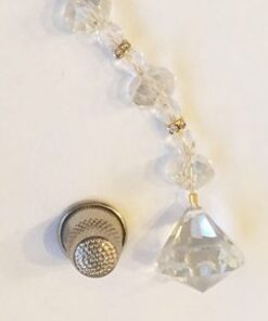 A close up of a string of beads with a thimble