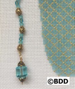 A blue bead hanging from the side of a gold chain.
