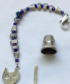 A cat charm and bead key chain with a thimble.