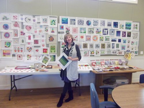 A woman standing in front of a table with many cards on it.