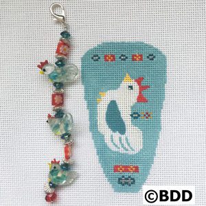 A blue and white bird with beads on it's tail.