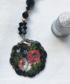 A close up of a necklace with flowers
