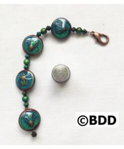 A bracelet with green beads and a metal bead.