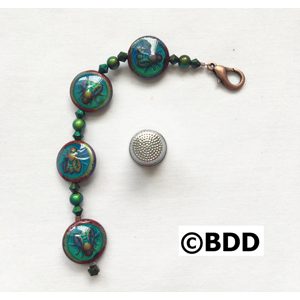 A bracelet with green beads and a metal bead.