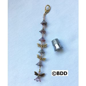 A key chain with five little dragonflies on it.