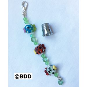 A keychain with beads and a thimble