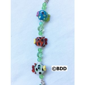 A bracelet with three different colored fish on it.