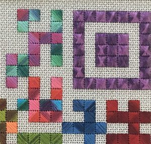 A close up of the letters h and q in cross stitch