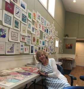 Artist displaying handmade cards on wall
