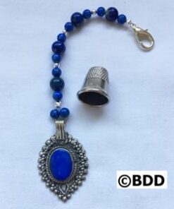 A blue bead and silver key chain with a thimble.