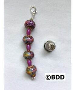 A pink and purple bead keychain with a thimble.