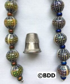 Center thimble flanked by patterned round beads