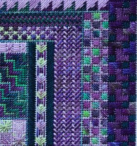 A close up of the purple and green pattern on a rug