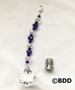A crystal bead hanging from the side of a string.