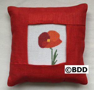 A red pillow with a picture of a flower.