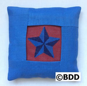 A blue pillow with a red star on it.