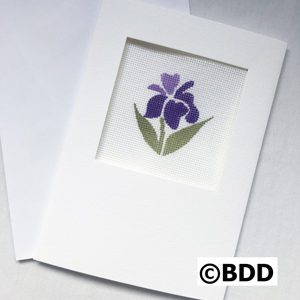 A purple flower sitting on top of paper.