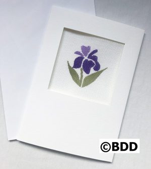 A purple flower sitting on top of paper.