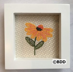 A cross stitch picture of a flower.