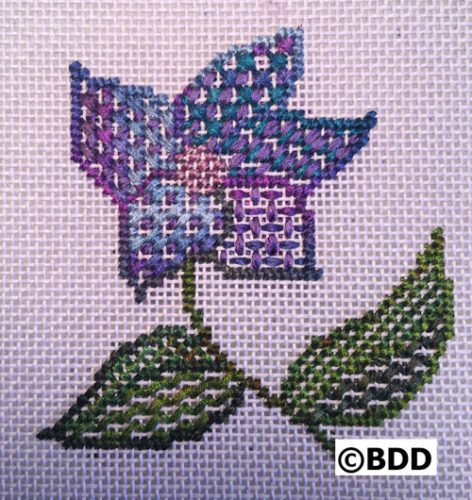 A cross stitch pattern of a flower with leaves.