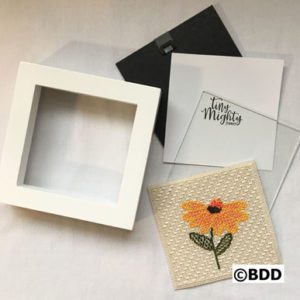 A white box with some paper and a flower