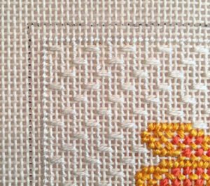 A close up of the cross stitch on a piece of fabric